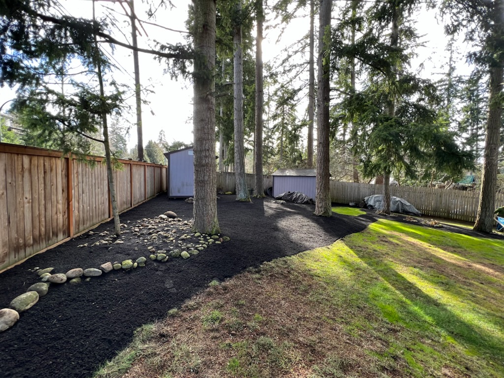 Rock border path along a cedar fence